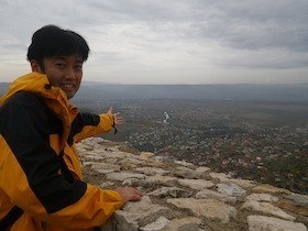 高台から街を眺める男性