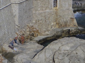 海岸沿いの城壁の下にいる人