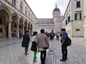 石造りの館の前にいる人