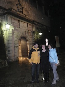 夜の通りで並ぶ三人の男女