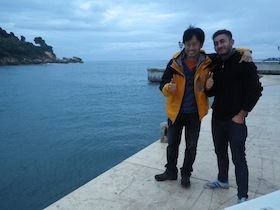 海辺で肩を組む男性二人