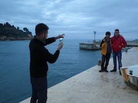 港で写真を撮る男性たち