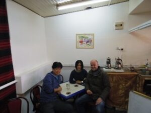 テーブルでお茶を飲む三人の男女